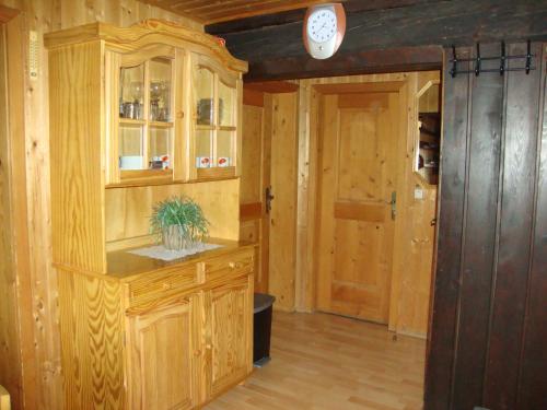 eine Küche mit Holzschränken und einer Uhr an der Wand in der Unterkunft Turner-Hütte in Heiligenblut