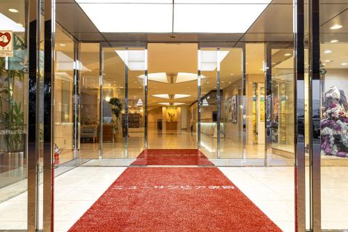 a glass corridor in a shopping mall with a red carpet at New Sunpia Tsuruga in Tsuruga