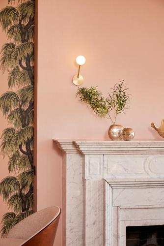 a living room with a fireplace and a pink wall at stilwerk Strandhotel Blankenese in Hamburg