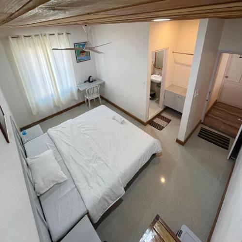 a bedroom with a white bed and a bathroom at Providence Guesthouse in Churāchāndpur