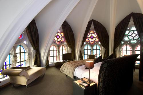 a bedroom with a bed and stained glass windows at Martin's Patershof in Mechelen
