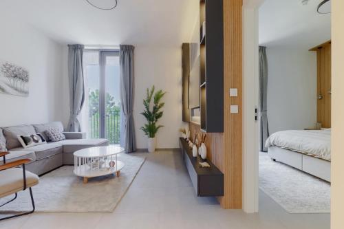 a living room with a couch and a bed at Sahab - Stunning 1BR with Terrace at the Bolivard in Sharjah