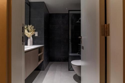 a black bathroom with a toilet and a sink at Sahab - Stunning 1BR with Terrace at the Bolivard in Sharjah