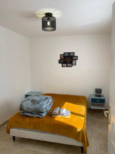 une chambre avec un lit avec une couverture jaune dans l'établissement Celle centre village proche therme, à Amélie-les-Bains-Palalda
