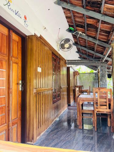 a dining room with wooden walls and a table and chairs at Mundro Garden Homestay in Munroe Island