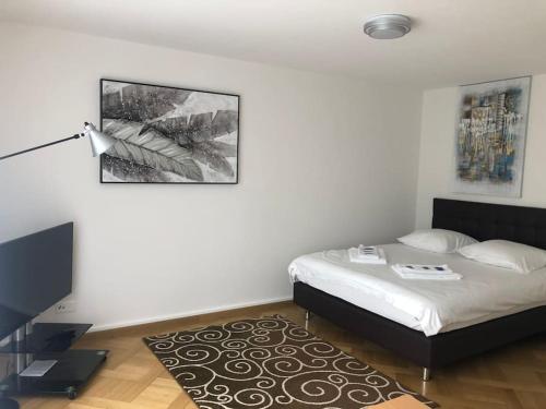 a white bedroom with a bed and a rug at Bright studio in the city center - Greenyard 1 in Zürich