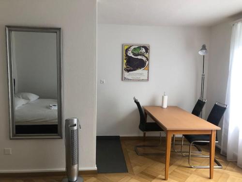 a dining room with a table and a mirror at Bright studio in the city center - Greenyard 1 in Zürich
