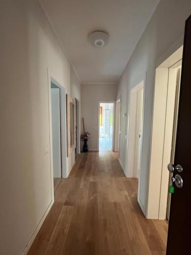 an empty hallway with white walls and wooden floors at Isabel BGY house airport in Grassobbio