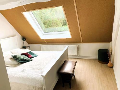 une chambre avec un lit blanc avec une fenêtre dans l'établissement Villa de charme 3 étoiles avec piscine, à Saint-Florent-sur-Cher