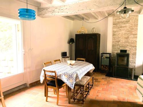 une salle à manger avec une table et des chaises et une cheminée dans l'établissement Villa de charme 3 étoiles avec piscine, à Saint-Florent-sur-Cher