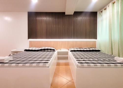 two beds sitting next to each other in a room at Green Meadows Hotel & Restaurant in San Nicolas
