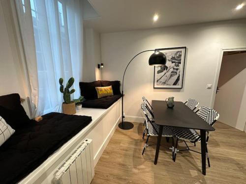 un petit salon avec une table et un canapé dans l'établissement Santa Fe, appartement neuf proche du centre-ville, à Reims
