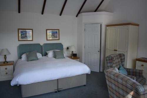 ein Schlafzimmer mit einem großen Bett und einem Stuhl in der Unterkunft Cardigan Castle in Cardigan