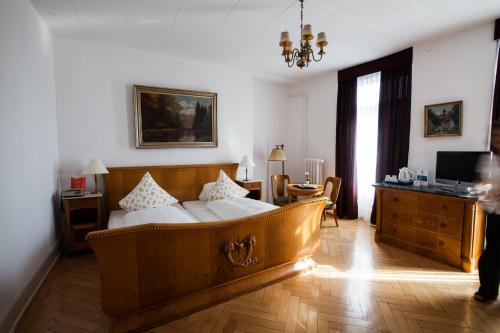 a bedroom with a large wooden bed in a room at Carlton-Europe Vintage Adults Hotel in Interlaken