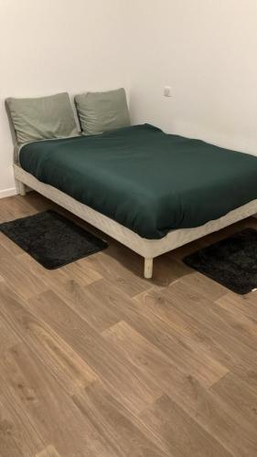 - un lit installé au-dessus du parquet dans l'établissement Bel appartement disponible, à Conflans-Sainte-Honorine