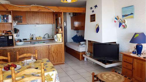 - une cuisine avec une table et une télévision dans la chambre dans l'établissement Superbe vue pour ce joli T2 en front de mer -Wifi -Direct Plage-5PC254, à Saint Cyprien Plage