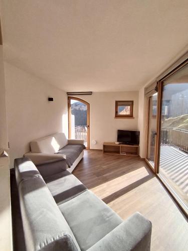 a living room with a couch and a television at Chalet MAOL Luxury Living in Valdidentro