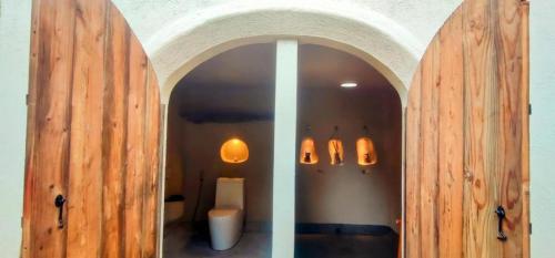 un bagno con servizi igienici attraverso una porta in legno di Firesky Glamping Ocam Ocam Beach a New Busuanga