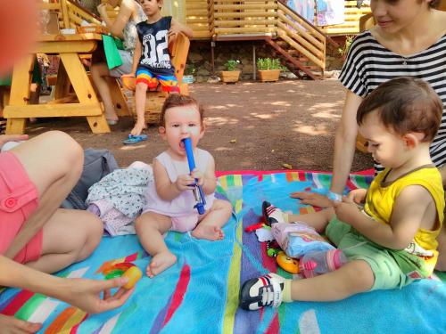 a group of children sitting on a blanket with a toothbrush at Chimera Pia Aparts in Cıralı