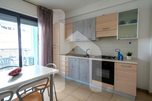 a kitchen with wooden cabinets and a table with chairs at Homiday - Holiday Rendez Vous in Pineto