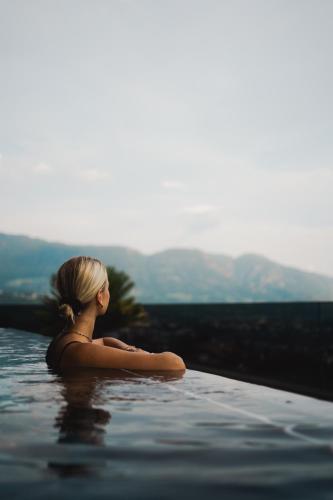 a woman is sitting in a swimming pool at Nutzhof - Mediterran Flair Hotel in Lagundo