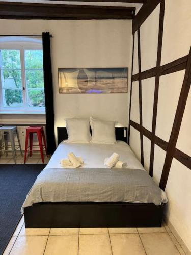 une chambre avec un lit avec deux serviettes dessus dans l'établissement Suite Schwendi - L'Authentique - en Hypercentre, à Colmar