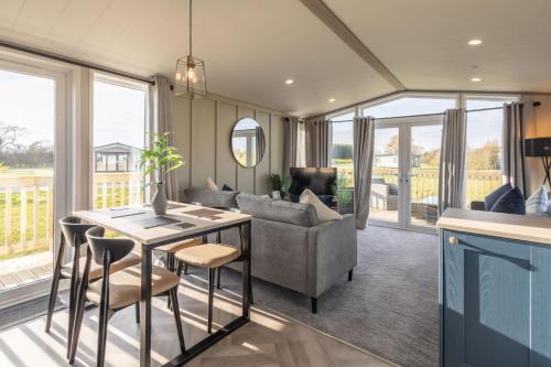 a living room with a couch and a table and chairs at Host & Stay - Riverwood, Ashdown Retreat in Pickering