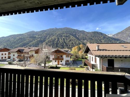 a view from a balcony of a town with mountains at Pinzolo Centro - Baita spaziosa con vista monti in Giustino