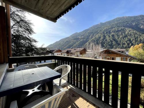 a table and chairs on a balcony with a view at Pinzolo Centro - Baita spaziosa con vista monti in Giustino