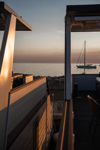 a boat on the water with a sailboat in the ocean at The Sea Lodges Novigrad - Hausboot Floating Sea House in Novigrad Istria