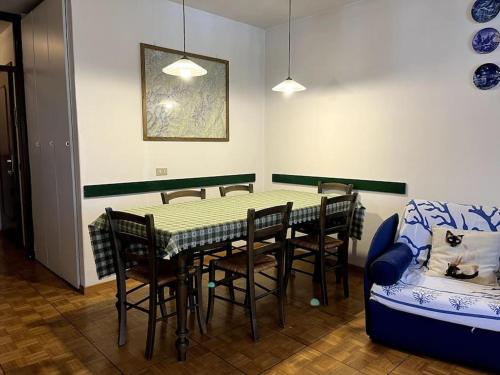 a dining room with a table and chairs and a couch at Pinzolo Centro - Baita spaziosa con vista monti in Giustino