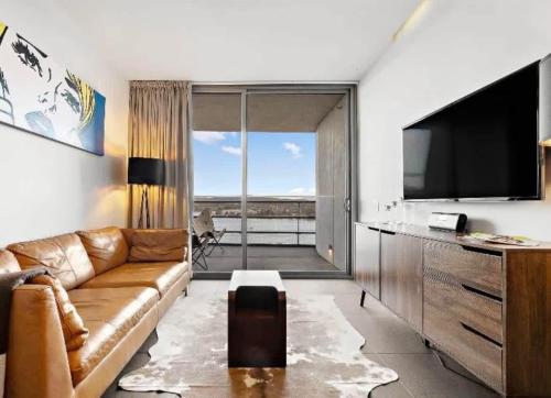 a living room with a couch and a flat screen tv at Nishi-Execs Couples and family retreat in Canberra