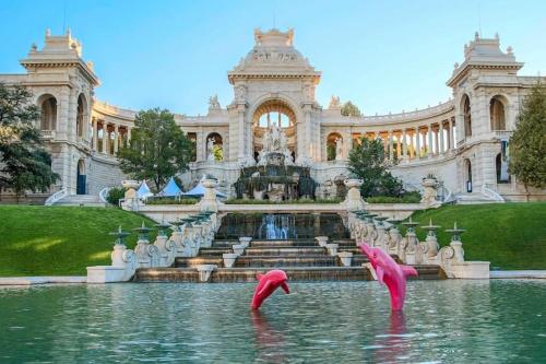 Deux flamants roses dans l'eau devant un bâtiment dans l'établissement T2 47m2 avec terrasse - Proche gare Marseille, à Marseille