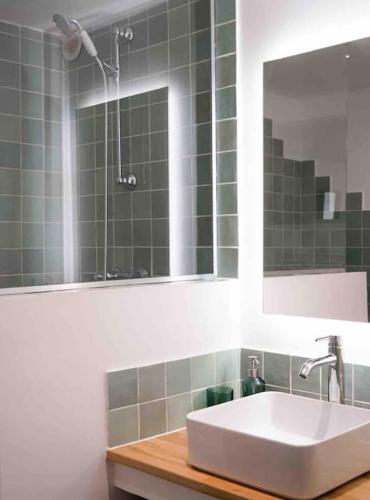 une salle de bain avec un lavabo et un miroir dans l'établissement T2 47m2 avec terrasse - Proche gare Marseille, à Marseille