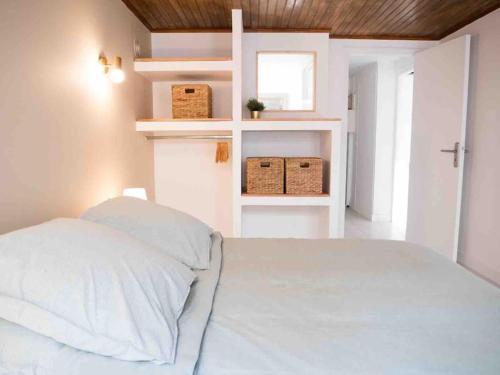 - une chambre avec un lit blanc et 2 étagères blanches dans l'établissement T2 47m2 avec terrasse - Proche gare Marseille, à Marseille