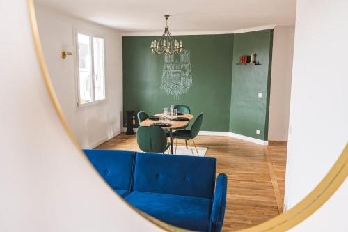 une salle à manger avec un canapé bleu et une table dans l'établissement Le Royal - Cathédral - Center, à Reims