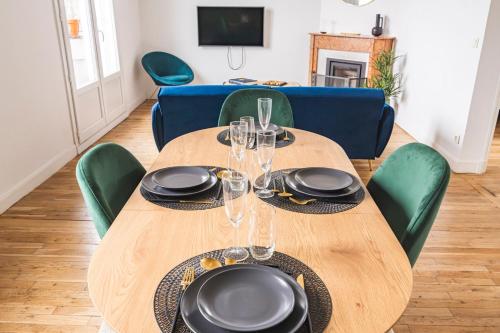 une table en bois avec des assiettes et des verres à vin dessus dans l'établissement Le Royal - Cathédral - Center, à Reims
