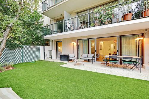 une arrière-cour avec une table et une pelouse dans l'établissement Passy - Eiffel Tower - Amazing 2BR with garden, à Paris