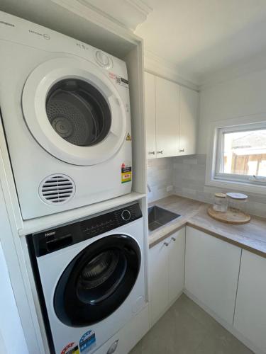 a washer and dryer in a small kitchen at Sunny room shared house in Ballarat