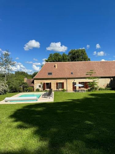une maison avec une piscine dans la cour dans l'établissement La maison de l'Allier, à Les Laurins