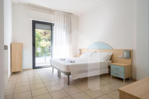 a bedroom with a large white bed and a window at Homiday - Holiday Rendez Vous in Pineto