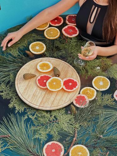 a woman sitting on the ground with citrus fruits on a cutting board at Dream Hotel in Haghpat