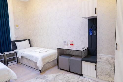 a small room with a bed and a table at Status Inn Hotel in Samarkand