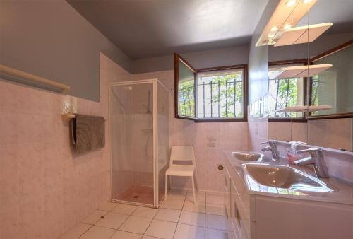une salle de bain avec un lavabo, une douche et un miroir dans l'établissement Villa Vignes, à Saint-Césaire-de-Gauzignan