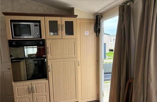 6 BERTH DELUXE PG159 GOLDEN PALM CHAPEL St LEONARDS في شابيل سانت ليوناردز: مطبخ مع ميكروويف وباب إلى نافذة