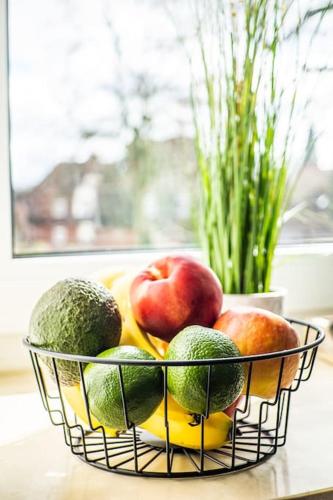 a basket of fruit on a table with a vase at Gemächliche Haushälfte mit 4 Schlafzimmern in Brunsbüttel