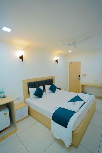 a bedroom with a large bed with blue pillows at The Balcony Suites I Gachibowli in Hyderabad