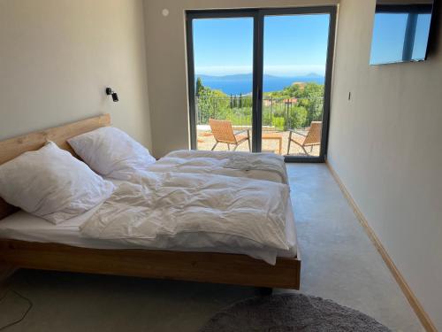 a bed in a room with a large window at Villa Castelina in Vicani