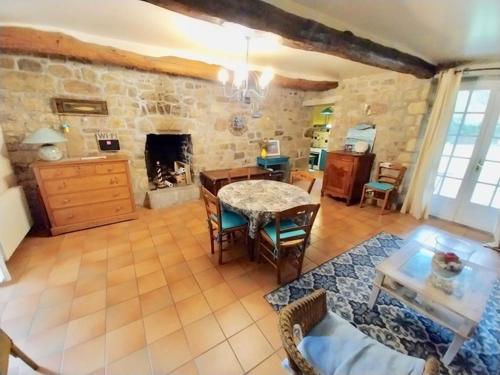 un salon avec une table et une cheminée dans l'établissement Campagne et mer a Erdeven, à Étel