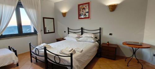 a bedroom with a bed and a table and windows at La Tana in Flumeri